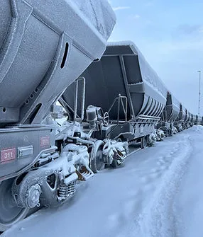 Frostiga malmvagnar på järnväg i vinterlandskap
